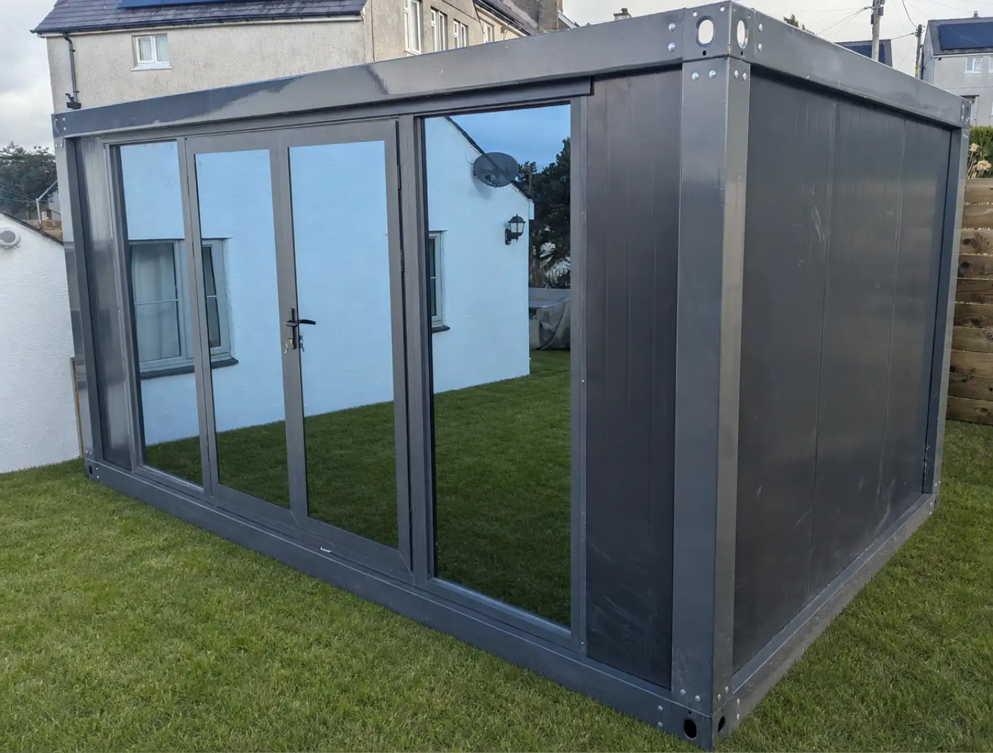 Caban garden room exterior, bi-fold doors open onto lawn